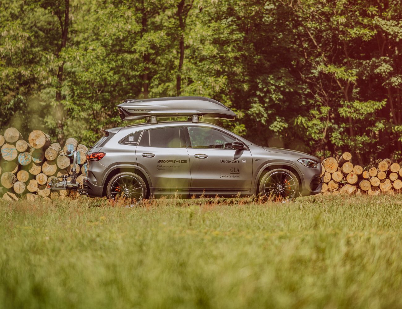 srebrny mercedes-benz gla ustawiony bokiem z bagażnikiem dachowym AMG