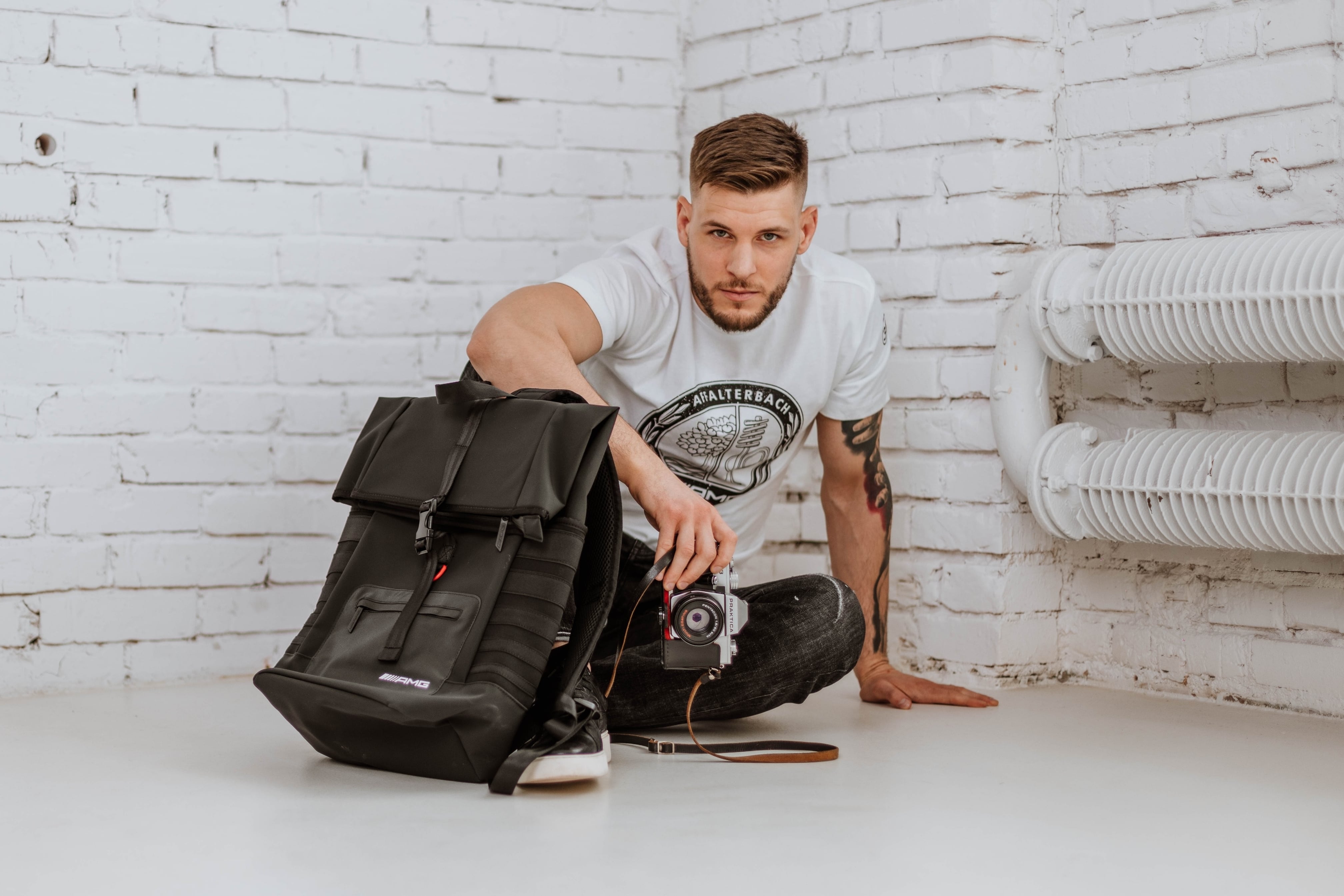 Model w koszulce Mercedes-AMG z czarnym plecakiem Mercedes-AMG